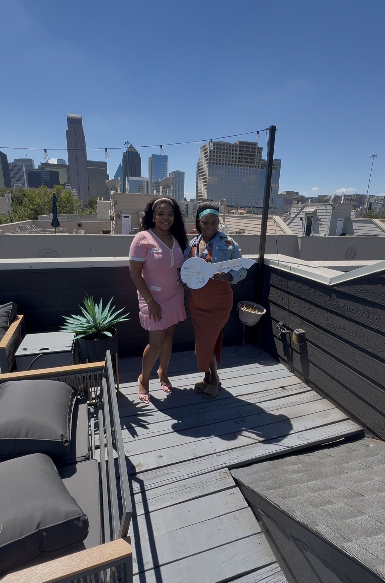 Shyanne handing keys to a new homeowner on a Dallas rooftop